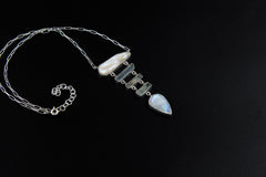 Raw Pearl Aquamarine Blue Moonstone necklace shown on a dark background with sterling silver wire link chain and aquatic pendant design.