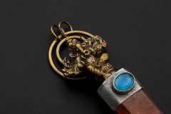 Close-up of gold-plated Ganesha figure and vivid blue Aquamarine cabochon set above Australian Lithium Quartz.