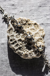 Freshwater Pearl sterling silver starburst bracelet shown on textured stone with soft white pearls and polished silver settings.