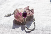 Amethyst oxidized sterling silver Byzantine bracelet shown on textured stone with deep purple oval cabochon.