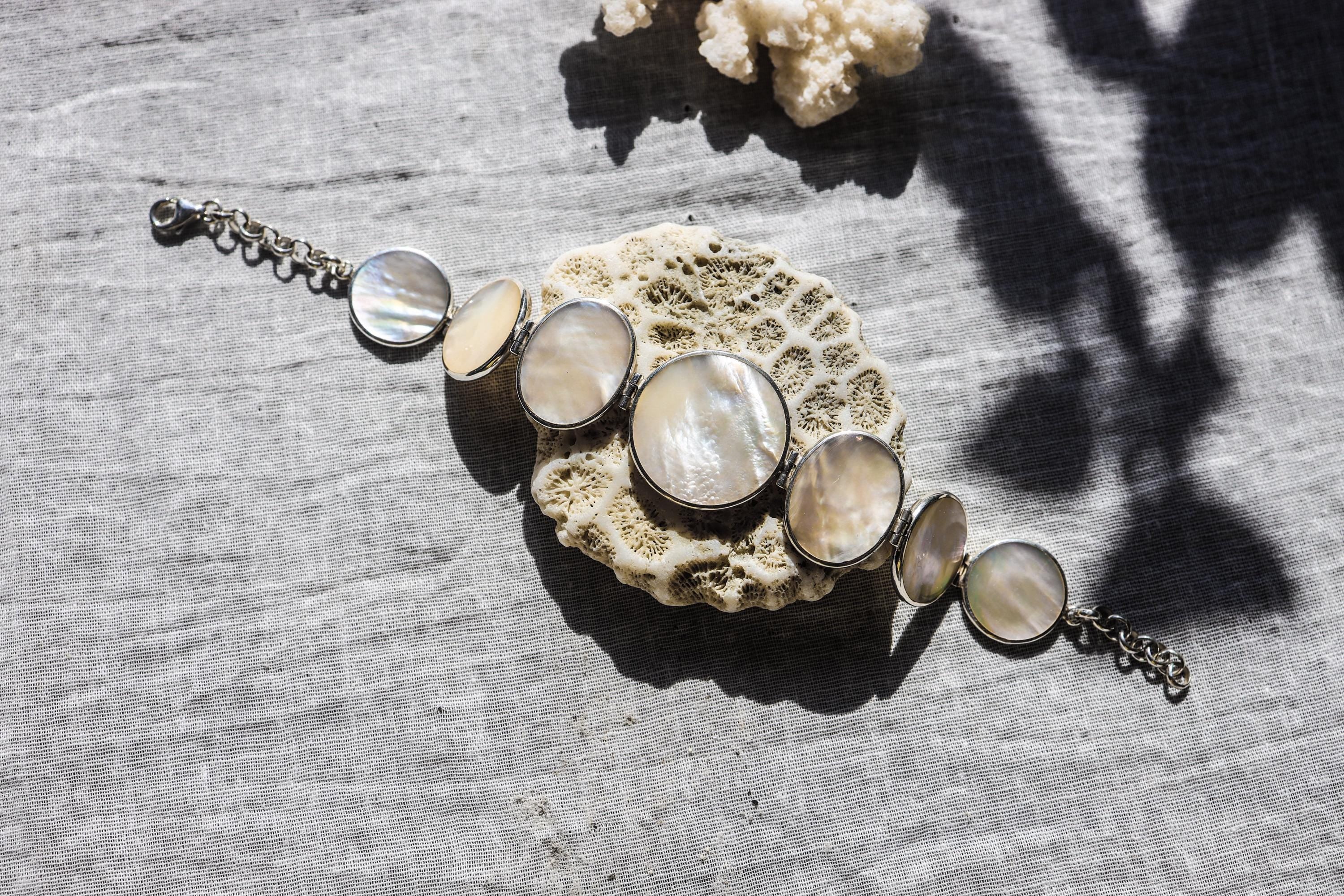 Mother of Pearl sterling silver bracelet shown on textured stone with soft nacre cabochons and polished silver settings.