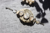 Mother of Pearl sterling silver bracelet shown on textured stone with soft nacre cabochons and polished silver settings.