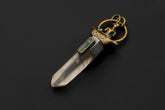 Buddha Lemurian Window Quartz Aquamarine pendant shown on a dark background with brass figure and oxidized silver setting.