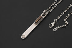 Brown Dravite Tourmaline spoon pendant shown with silver chain on dark background and high-shine sterling silver.
