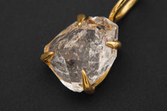 Close view of Herkimer Diamond Quartz pendant in 18k gold-plated sterling silver claw setting.