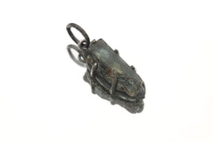 Raw Blue Tourmaline claw pendant on white background with oxidized sterling silver setting and rugged handmade texture.