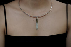 Dravite Tourmaline sterling silver wand pendant worn on a model as a minimal grounding crystal necklace.