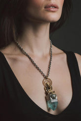 Ganesha Aqua Aura Quartz and Blue Tourmaline talisman shown worn on a model, with brass motif and sterling silver setting.
