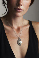 Ancient Tide Pearl crescent pendant shown worn on a model, with oxidized sterling silver texture and luminous white Pearl.