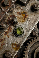 Peridot claw pendant shown worn on a model, with oxidized 925 sterling silver setting and bright green August birthstone.