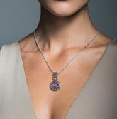 Purple Vesuvianite Pearl Peridot nest pendant shown worn on a model, with gunmetal oxidized sterling silver setting.