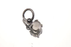 Close-up of Cat’s Eye Moonstone pendant in oxidized sterling silver claw setting with silvery-white oval gemstone.