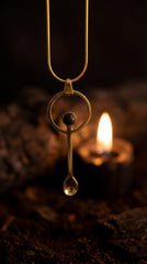 Mount Agung volcanic stone brass ritual spoon shown worn as a pendant near candlelight.