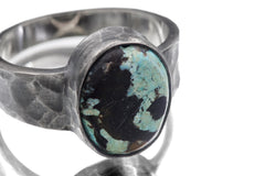 Close-up of Tibetan Turquoise oval cabochon ring showing earthy green matrix and oxidized hammered silver bezel.