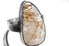 Close-up of tooth-shaped Clear Quartz ring showing Golden Rutile needle inclusions and oxidized silver bezel.