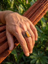 Raw Orange Kyanite men’s ring in oxidized 925 sterling silver shown worn on the hand with hammered texture.