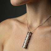 Pearl Cube Cage Pendant shown worn on a model, with oxidized sterling silver frame and loose moving Pearls inside.