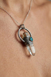 Brown Tourmaline Emerald Lemurian Quartz pendant shown worn on a model, with oxidized sterling silver and raw crystal point.