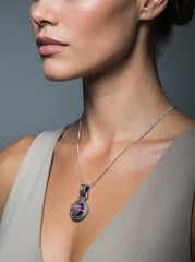 Vesuvianite Pearl Peridot pendant shown worn on a model, with compact circular nest setting and dark silver finish.