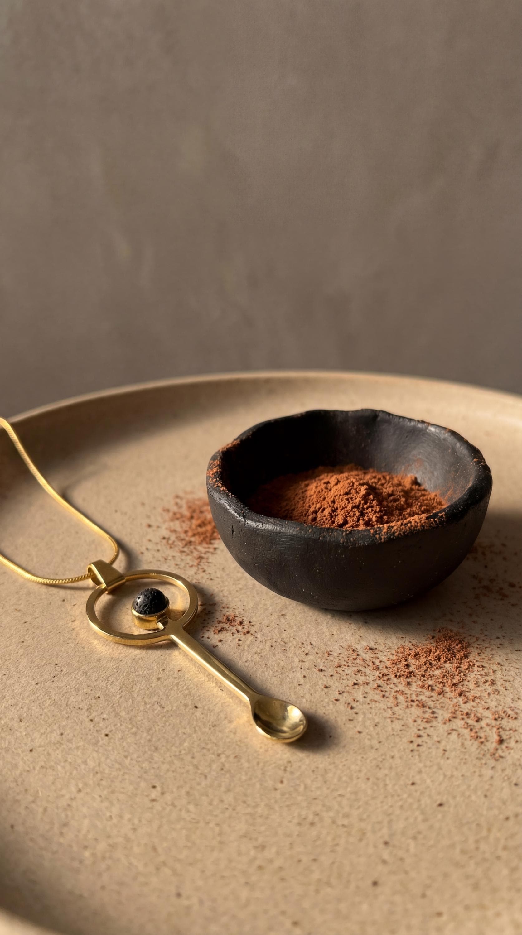 Mount Agung volcanic stone gold-plated brass ritual spoon shown near offering bowl with dark stone cabochon.