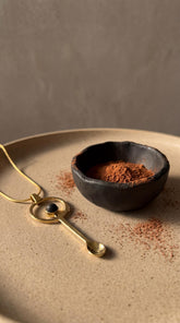 Mount Agung volcanic stone gold-plated brass ritual spoon shown near offering bowl with dark stone cabochon.