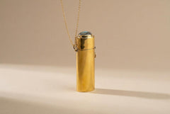 Keeper of Hidden Flame brass lighter box pendant shown standing upright with chain and polished golden surface.