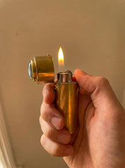 Functional brass lighter box pendant shown in hand with flame lit, Labradorite lid detail, and polished brass body.