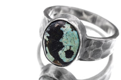 Close-up of Tibetan Turquoise oval cabochon ring showing earthy green matrix and oxidized hammered silver bezel.