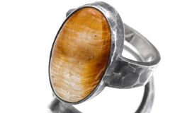Close view of oval Gold Rutilated Quartz ring showing golden needle inclusions in clear crystal.