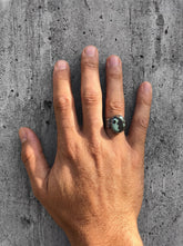 Old World Tibetan Turquoise men’s ring in oxidized 925 sterling silver shown worn on the hand with hammered texture.