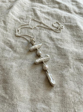 Blue Moonstone and Pearl cascade pendant displayed on linen, with high-shine sterling silver and flowing vertical dangle design.