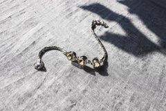 Citrine bracelet shown on textured stone with oxidized sterling silver Byzantine chain and golden stones.