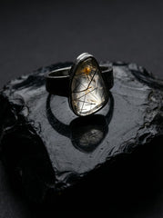 Black Rutile Quartz sterling silver ring displayed on dark stone with hammered oxidized silver band.