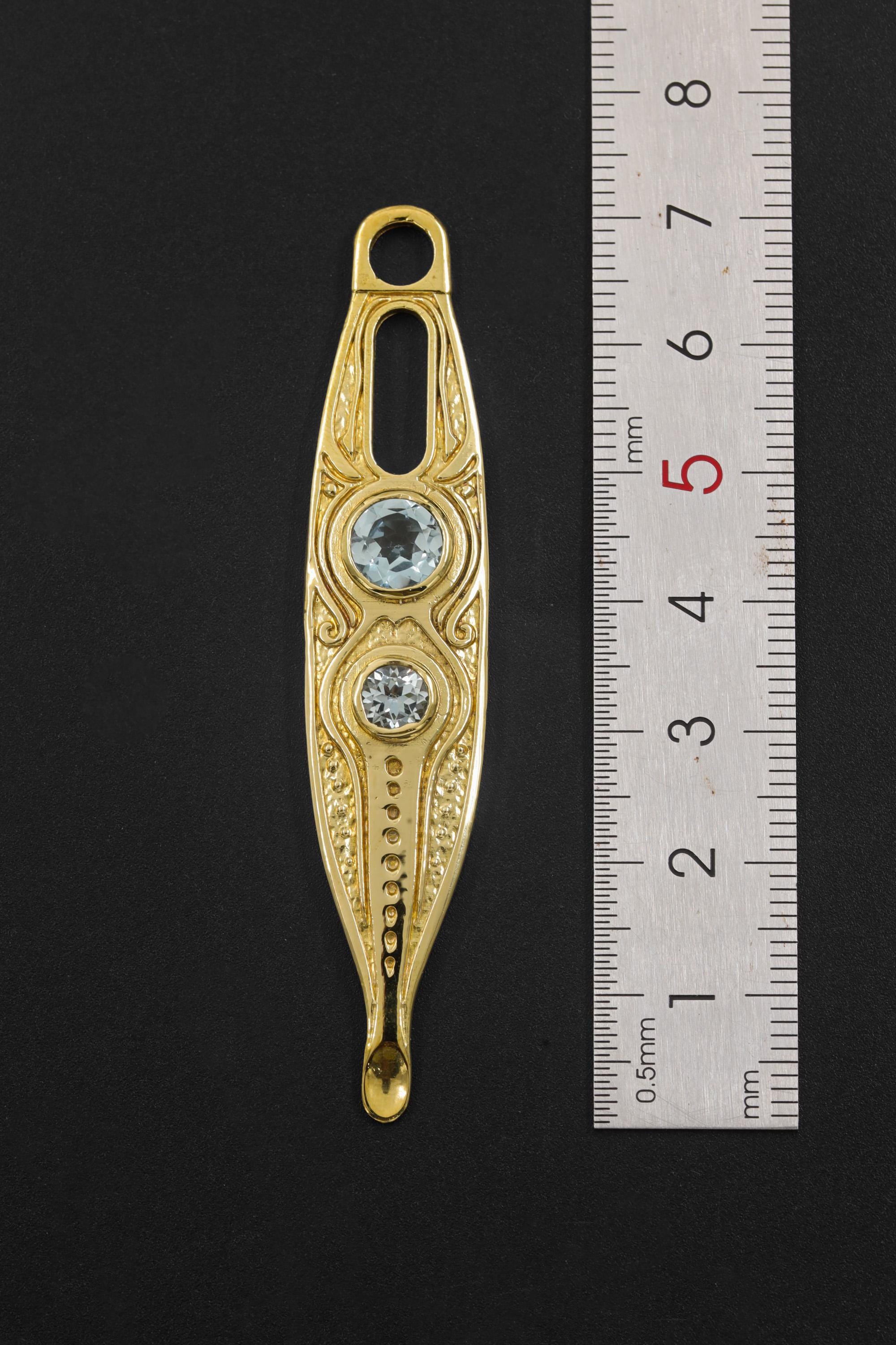 Gold Plated Blue Topaz Spoon Talisman shown beside a ruler for scale, with integrated bail and long brass spoon form.