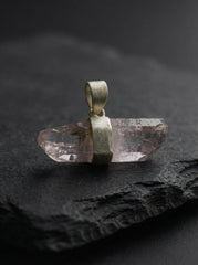 Anhydro Vera Cruz Amethyst crystal pendant displayed on dark stone with sterling silver bail.