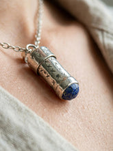 Lapis Lazuli capsule pendant shown worn on model with polished sterling silver and adjustable necklace.