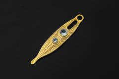 Blue Topaz spoon pendant shown on a dark background with 18k gold-plated brass, carved detail, and two blue stones.