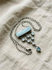 Enchanting Opal Aquamarine Apatite necklace shown on natural fabric with oxidized sterling silver, blue gemstones, and box chain.