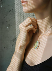 Lightning Ridge Boulder Opal pendant shown worn on a model, with textured sterling silver and large freeform opal face.