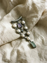 South Sea Pearl Charoite Moonstone Aquamarine pendant shown on fabric with oxidized sterling silver and long ocean-inspired design.