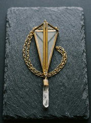 Brass triangle prism crystal sun catcher shown on slate with Clear Quartz point and golden hanging chain.