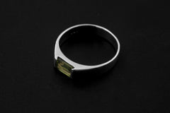 Peridot sterling silver ring displayed on dark background showing modern geometric band profile.