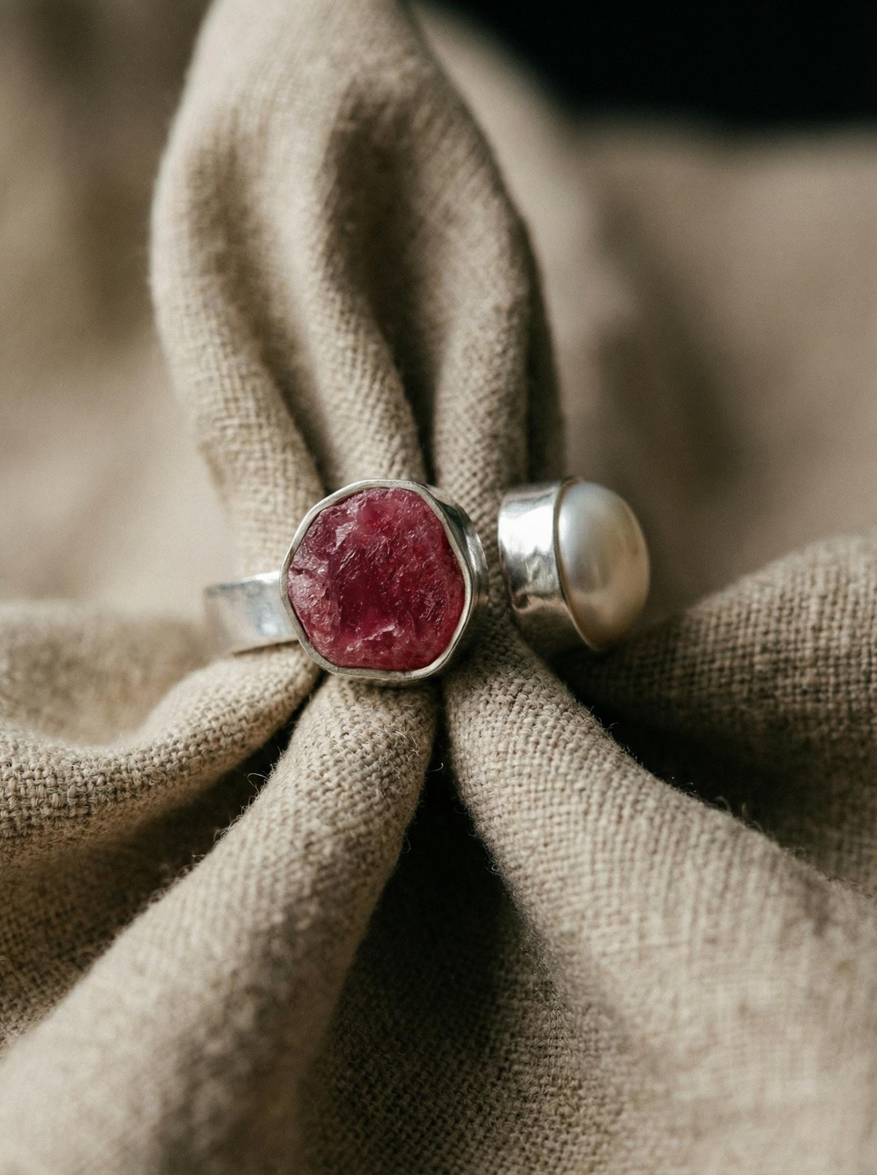 Ruby South Sea Pearl adjustable ring in high-shine 925 sterling silver shown on soft natural fabric with hammered texture.