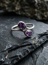 Twin Amethyst open ring displayed on dark slate with polished sterling silver and violet gemstones.