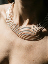 Six layer sterling silver choker shown worn on model with polished parallel collar lines.