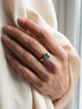 Raw Blue Apatite Gem Ring shown worn on hand with hammered sterling silver band and vivid blue-green stone.