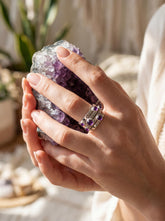 Five stone Amethyst sterling silver ring shown held in hand with polished band and violet cabochons.