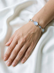 Rainbow Moonstone bracelet displayed on fabric with oval and round cabochons in sterling silver bezels.