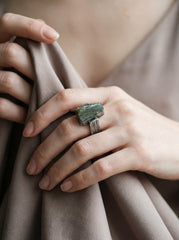Labradorite statement ring shown worn on hand with thick sterling silver band and raw stone face.