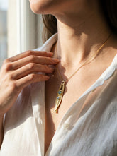 Gold Plated Blue Topaz Spoon Talisman worn as a pendant necklace, with sculptural brass spoon form and gemstone detail.